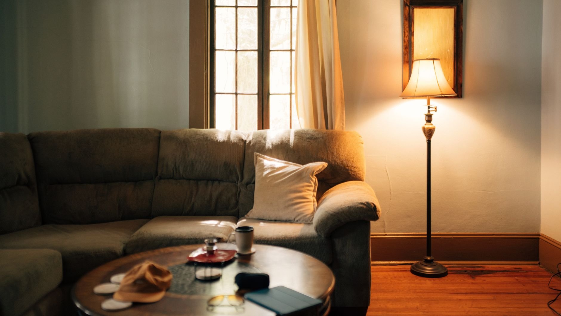 A warm, inviting vacation rental living room with sofa, coffee table, and floor lamp